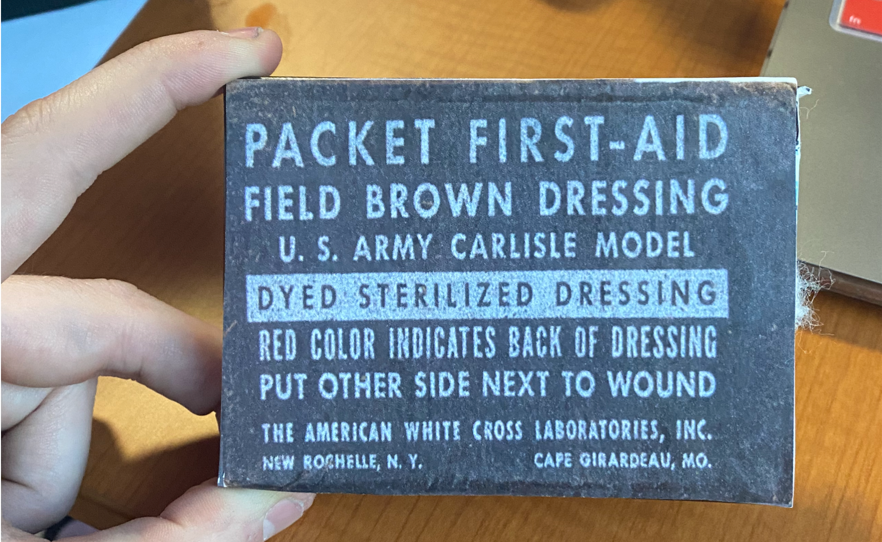 Recreation of a dyer sterilize dressing bar. The label states that to use "put other side next to wound". The label includes the name of the manufacturer and the place where it was produced