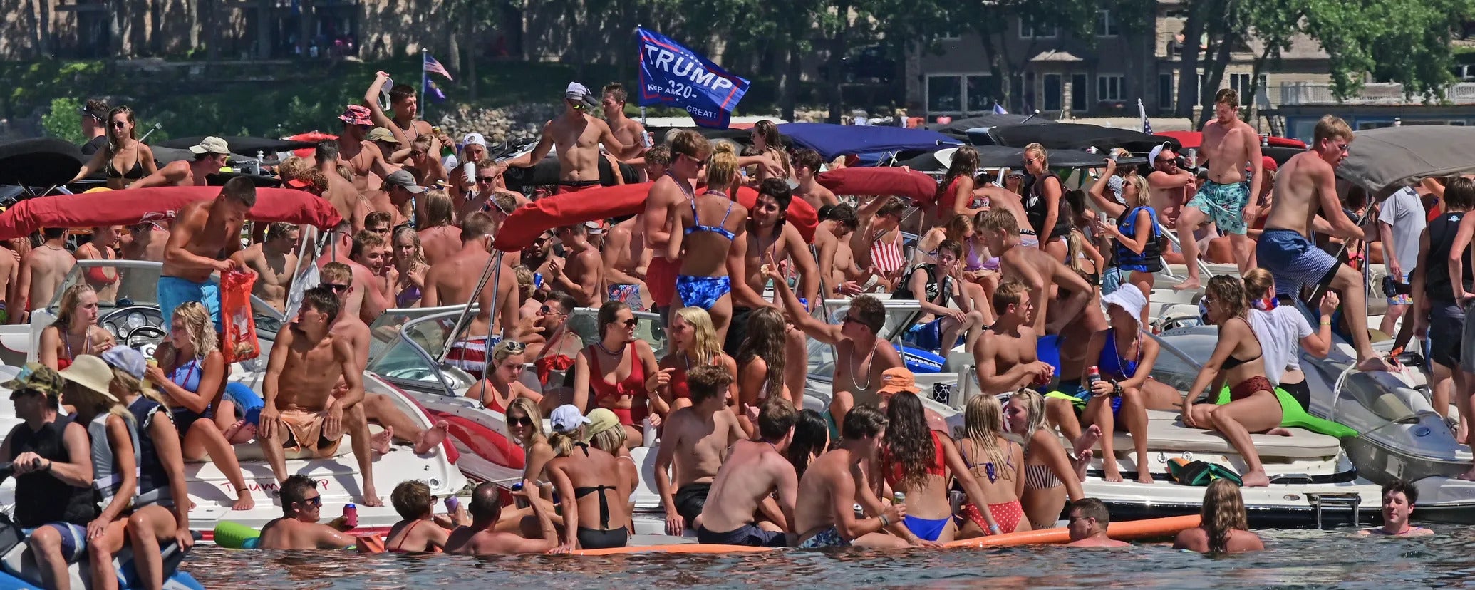 A party on Lake Okoboji in the Iowa Great Lakes region over July Fourth weekend. There are numberous individuals and none of them wears a mask