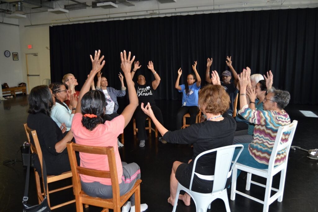 Dance exercise. Group sitting in a circle, stretching their arms