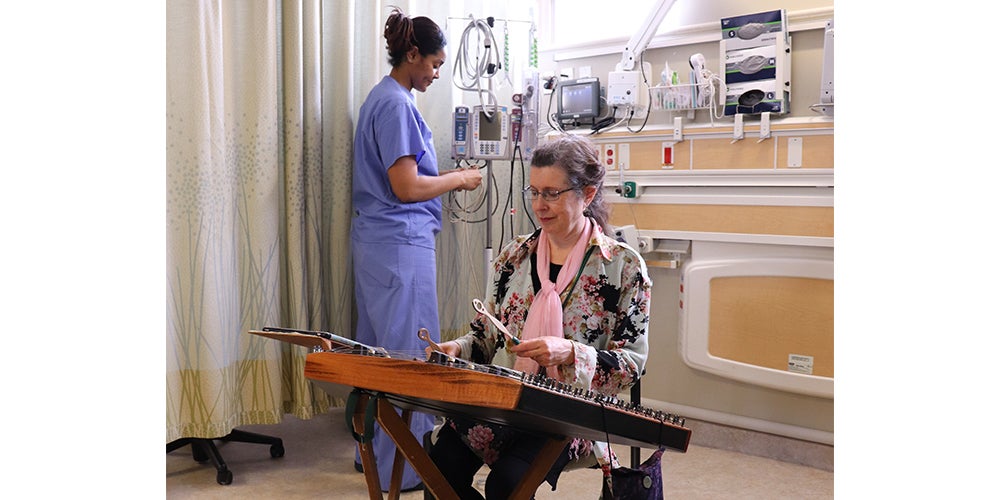 Karen Ashbrook playing hammered dulcimer for patients at MedStar Georgetown University Hospital