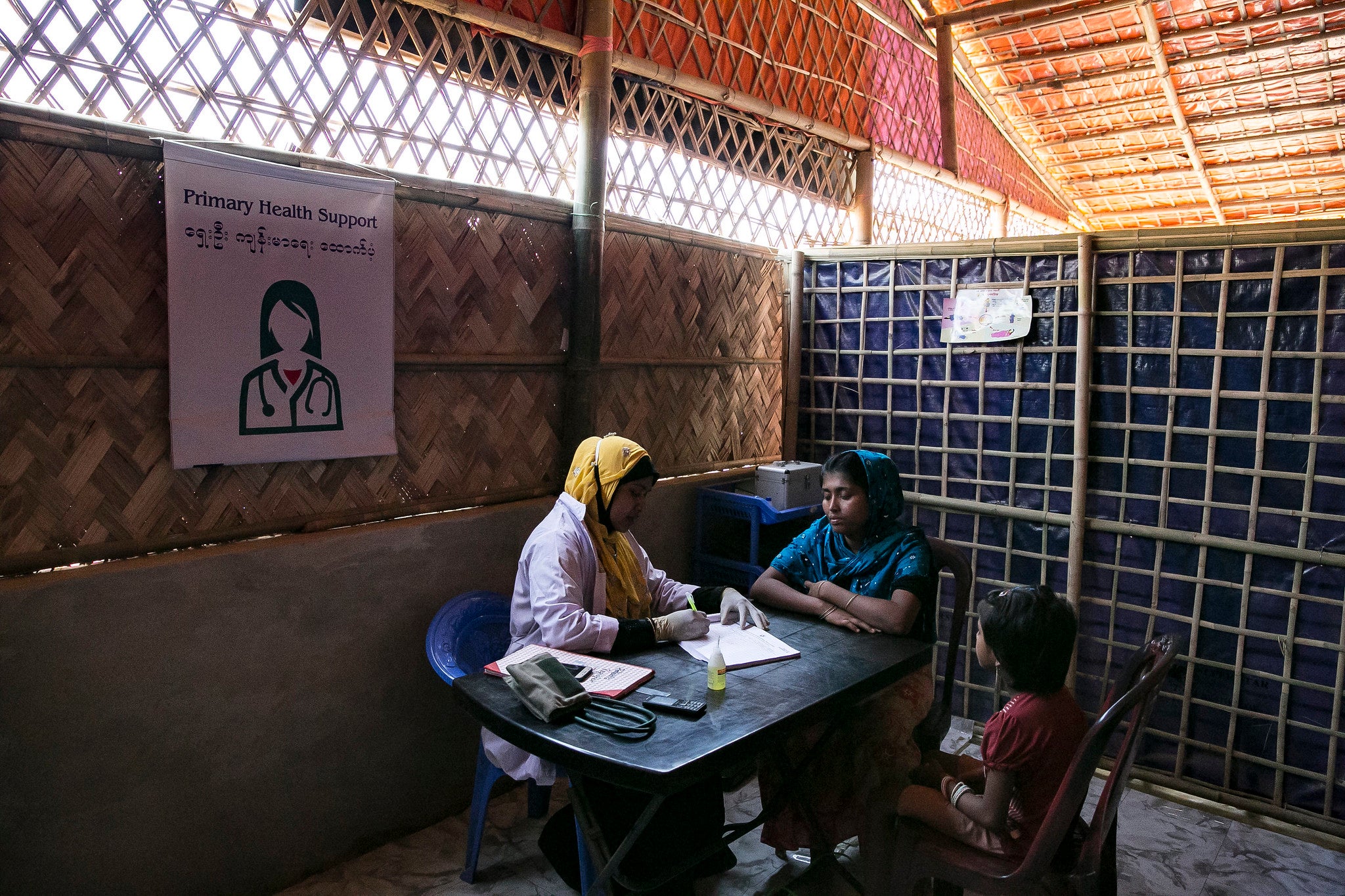 Rohingya refugee woman, with her child, on a health appointment inside a refugee camp