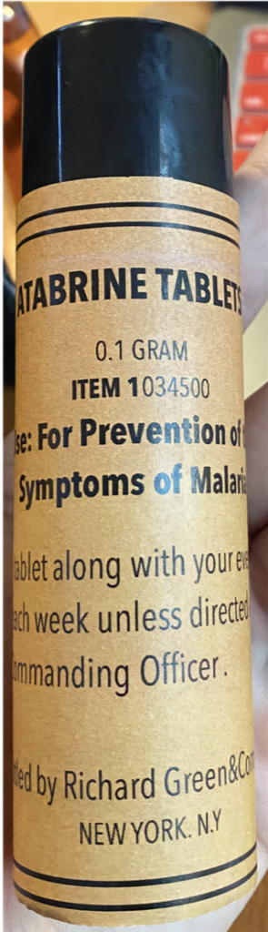 Recreation of a bottle with atabrine tablets. The label includes directions of use, the name of the manufacturer and the place where it was produced