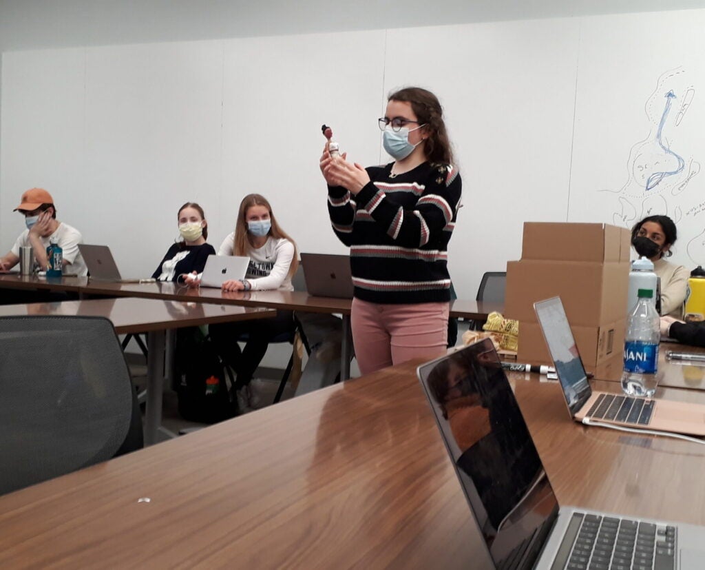 Layan Shahrour displays her project about the usage of plant-based materials in the mummification process in the New Kingdom of Egypt, before the Intro to Medical Humanities class. She is holding a doll, representing the body that would be wrapped as a mummy in a sarcophagus