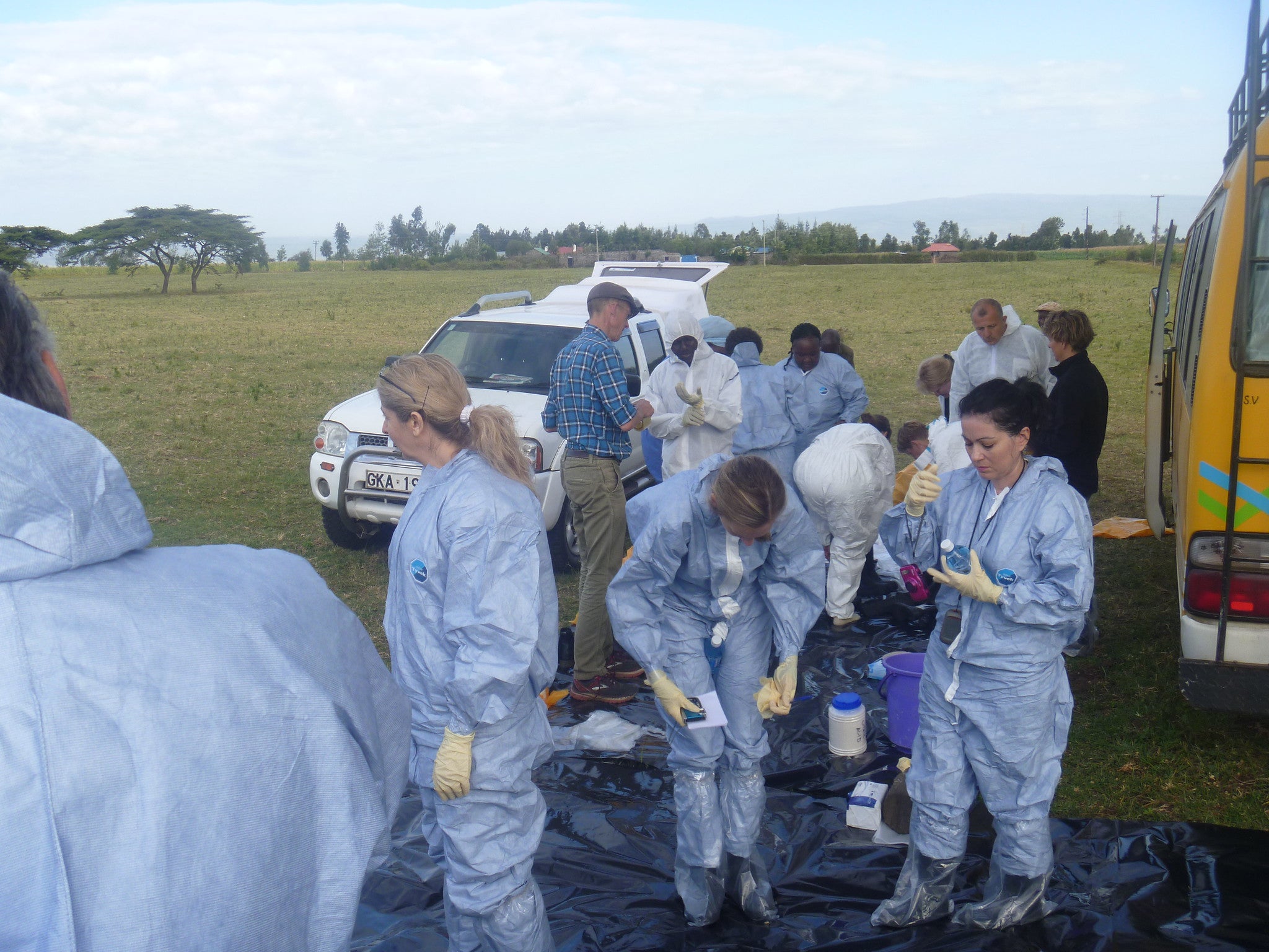 Group of researchers wearing protective garments, conducting biomedical research on the field